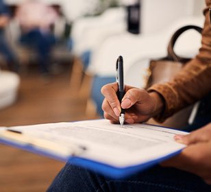 Woman filling out dental insurance form in lobby