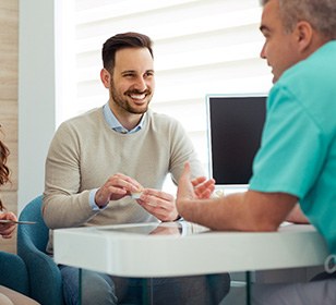 Dentist and couple talking in dental office