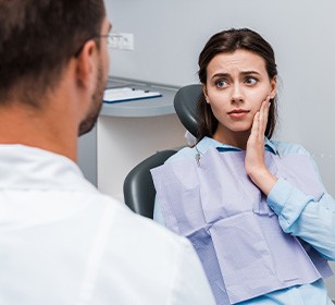 Woman with toothache talking to dentist 