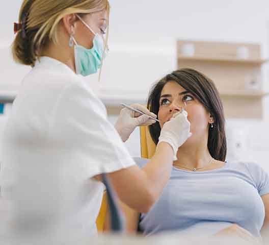 A dentist performing gum disease treatment on a woman