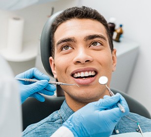 Man with brown hair and blue shirt about to have a dental exam