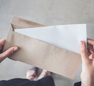 First person view looking down at a cardboard envelope containing a letter